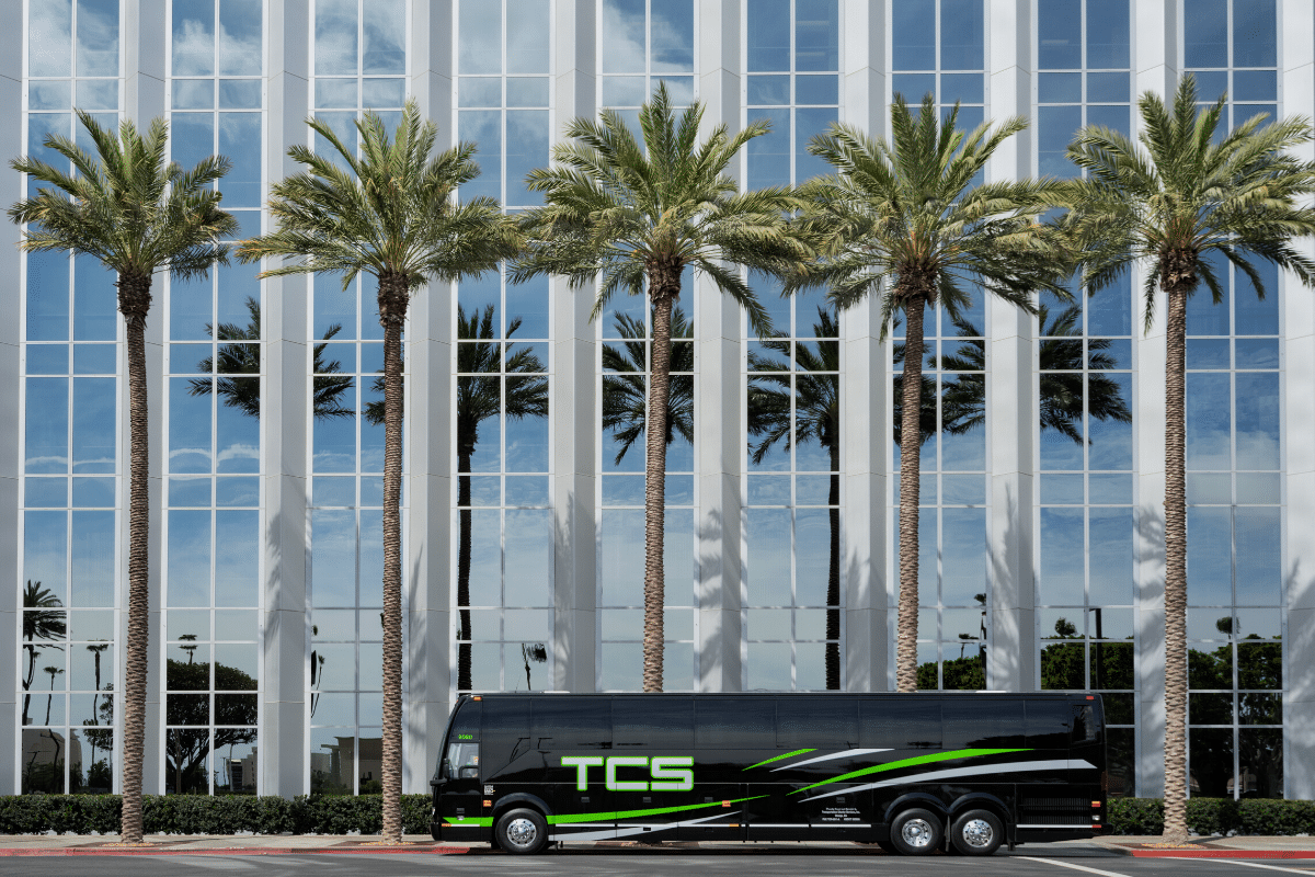 TCS charter bus in front of palm trees and building Los Angeles, California