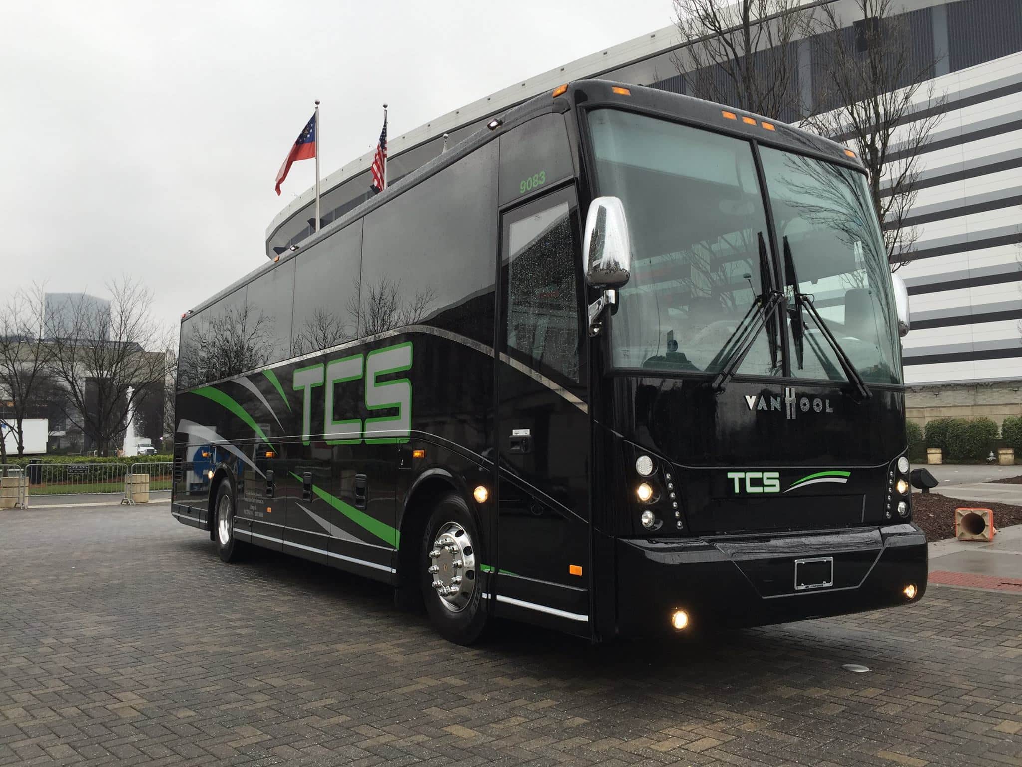 a black bus parked on a brick road